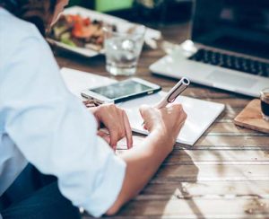 small-business-owner-writing-on-a-pad-with-pen