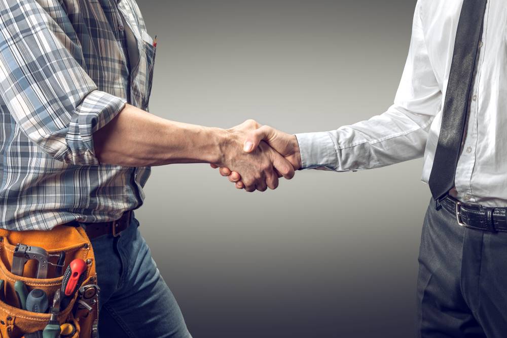 construction worker and business man shaking hands